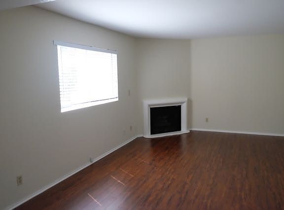 Living room with gas fireplace overlooking park.