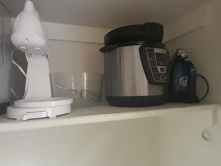Pantry. Mixer, pressure cooker/crock pot, iron. There is an ironing board below the shelf.