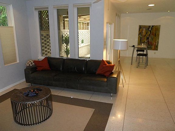 Den with dining room in background and a private patio.