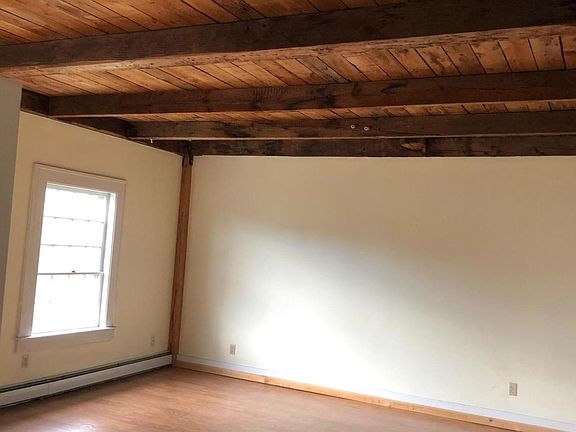 large bedroom with closet and two big windows overlooking backyard meadow