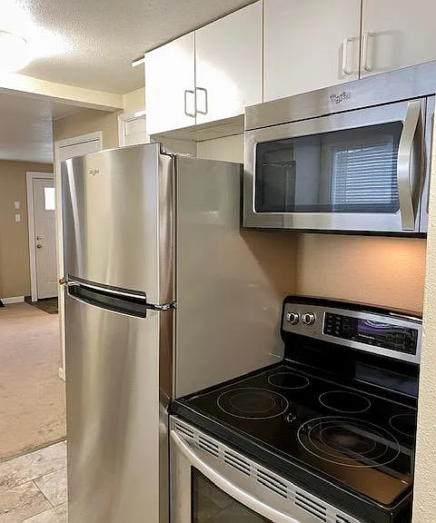 Kitchen with stainless steel appliances including a brand new refrigerator