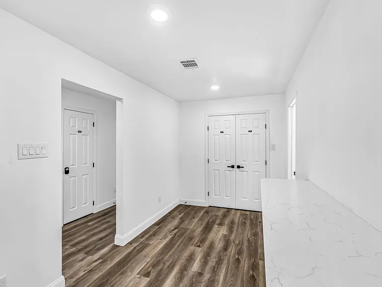 Small hallway leads to the shared open dining hall with counter top bar.
