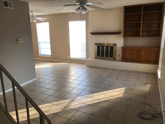 Living room with tile floors, gas fireplace, built-in shelve