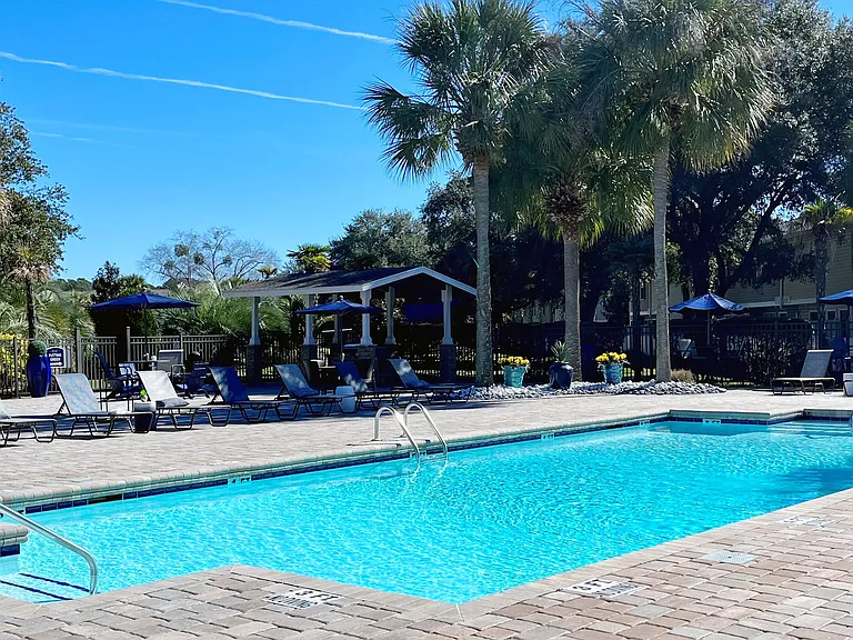 Witness the allure of our radiant resort-style pool, embraced by a tropical landscape offering 'vacation at-home 365' vibes.