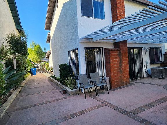 View of the side & backyard with concrete flooring & patio cover