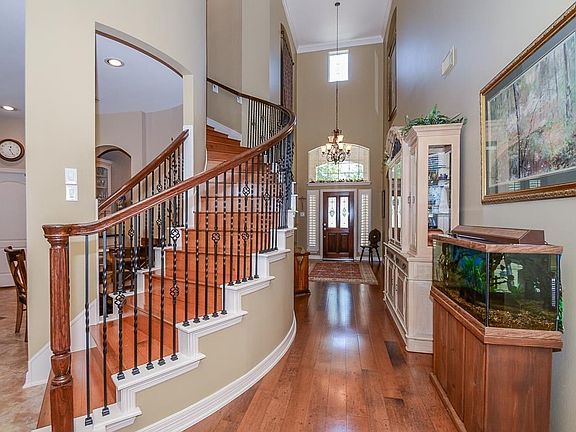 The hardwoods from the entry lead to spiral staircase with elegant wrought iron spindles.
