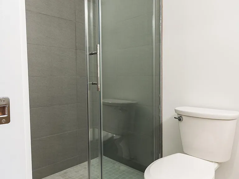 Remodeled bathroom with tile floors, walk in shower and glass door