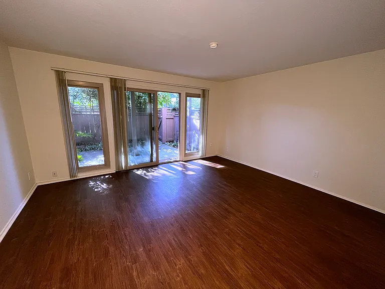 Jr 1BR living room, looking out onto shady private patio. Most of our downstairs units have hardwood flooring like this in the living rooms, and carpet in the bedrooms.