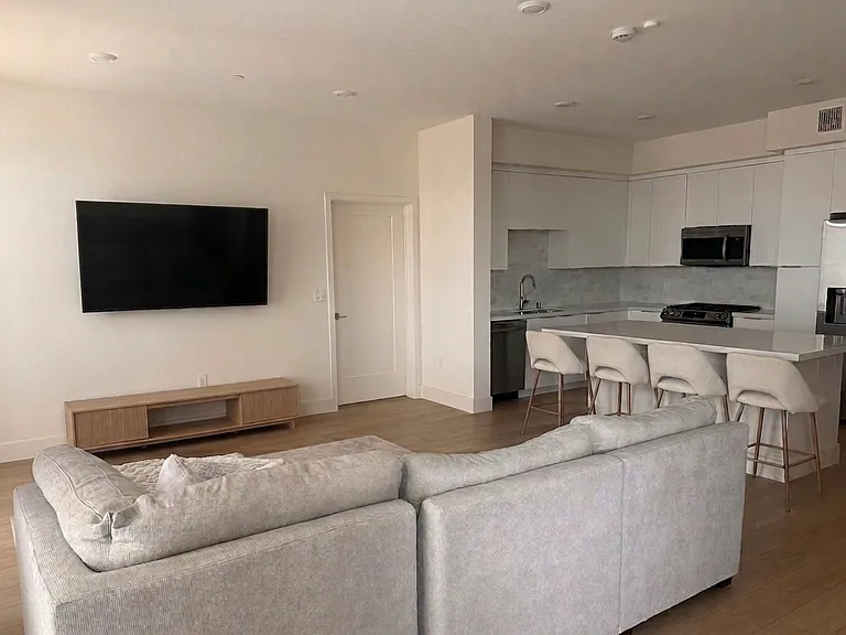 Gourmet kitchen with a large island. Spacious Living room with light filtering and privacy cellular shade window coverings that maximize energy efficiency with an elegant look
