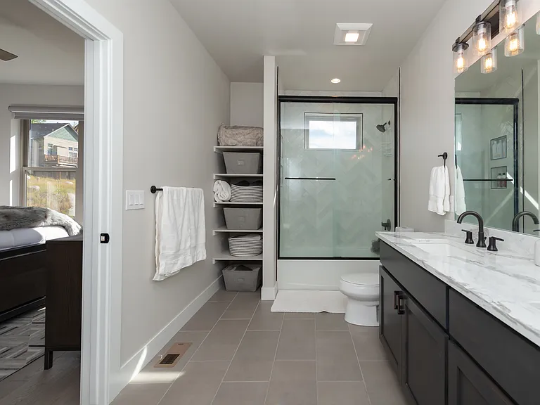 Elegant ensuite featuring dual vanities, abundant cabinet storage, and refined finishes for a spa-like experience.