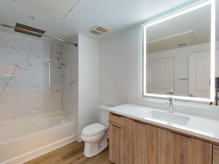 Apartment Bathroom with large soaking tub and Wood Style Flooring.