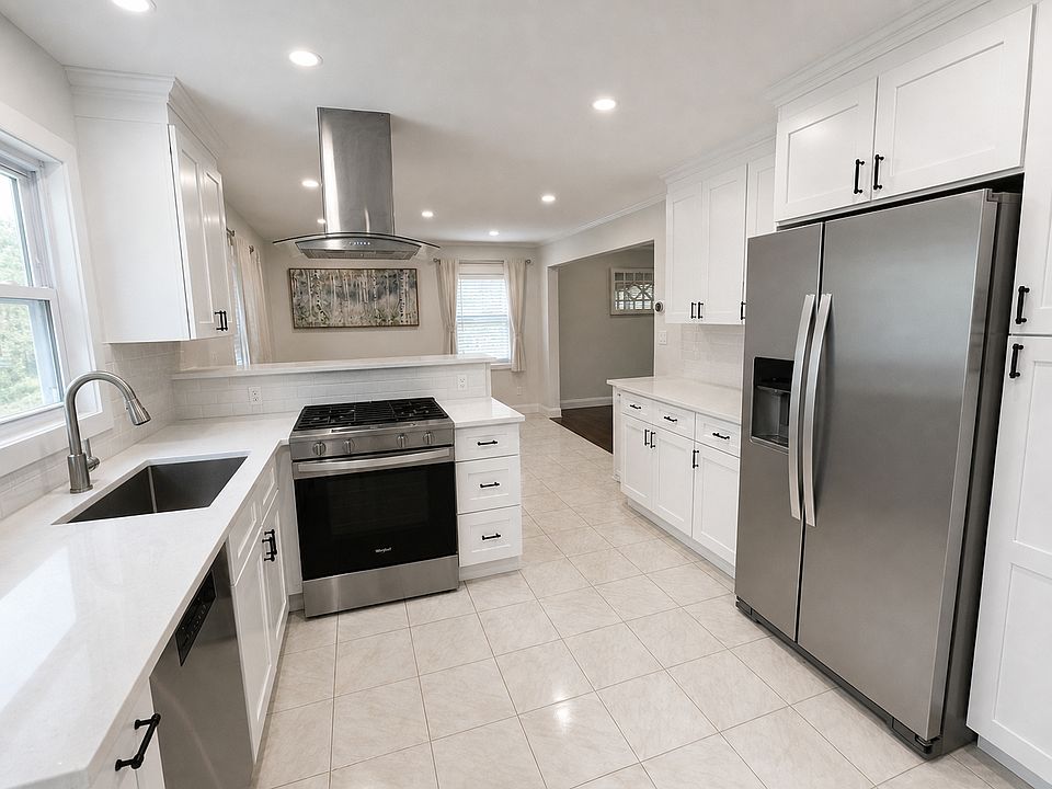 Fully renovated and bright, open concept kitchen with farmhouse sink, quartz countertops and stainless steel appliances.