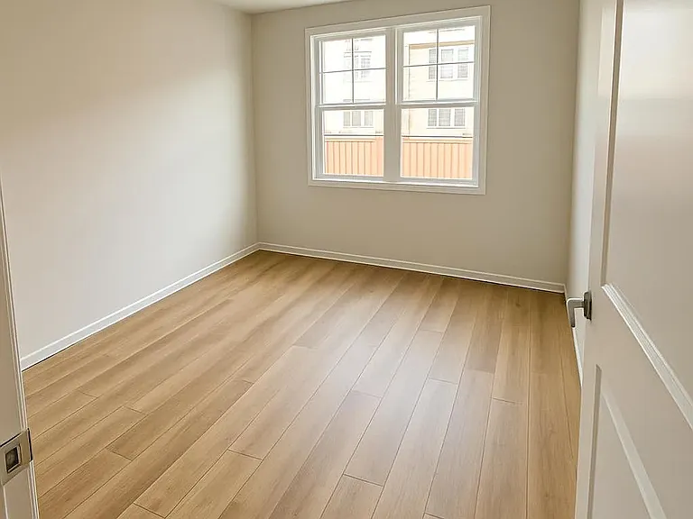 Primary Bedroom with Double WIndows and Luxury WIde Oak Planked Flooring (LVT).