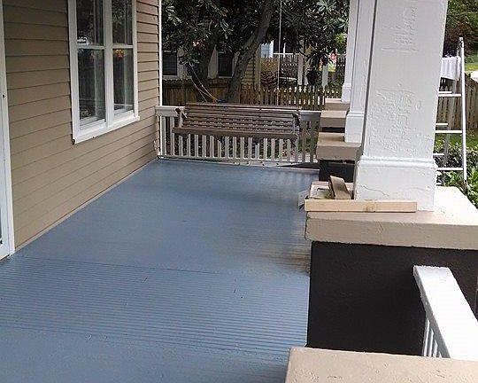 Large front porch with wooden swing and plenty of room for outdoor entertaining with shade and privacy.