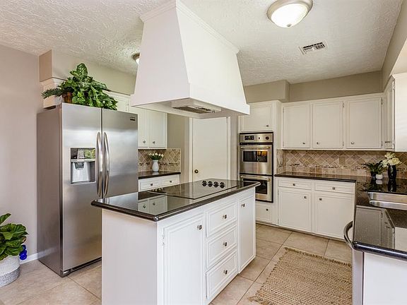 Light and bright kitchen with black granite counters and double ovens! The refrigerator stays!