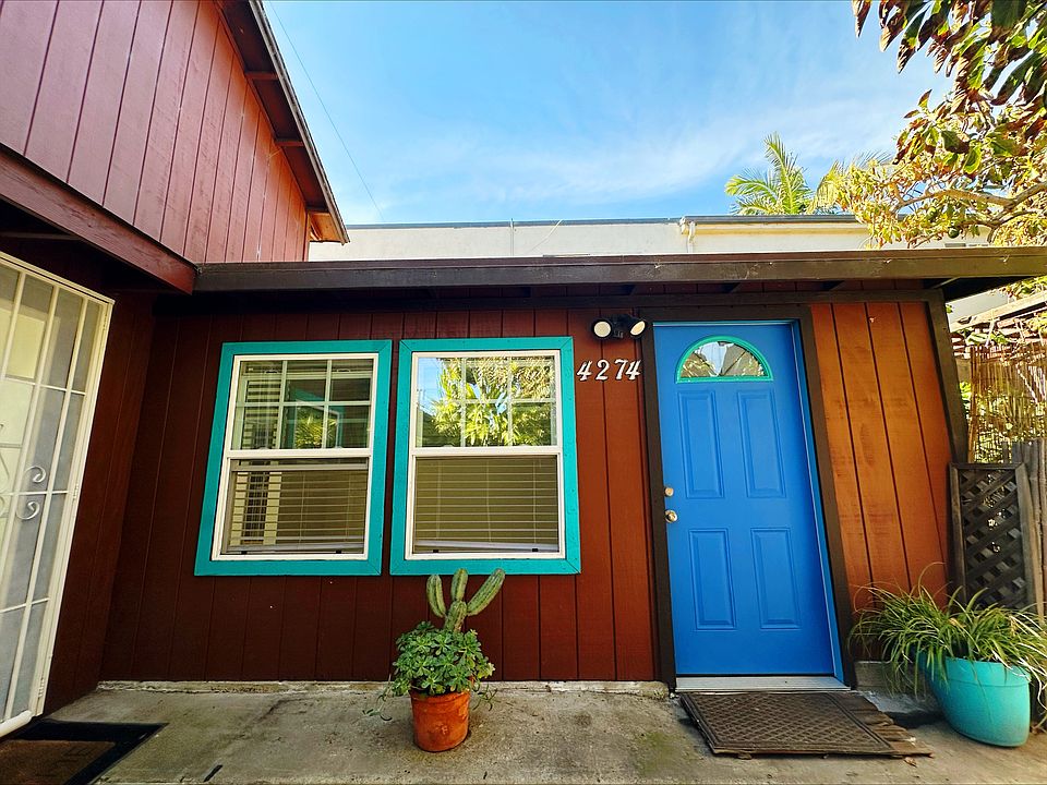 Main entrance to main unit, beautiful blue door leads to living room, white security door entrance on left leads to kitchen.