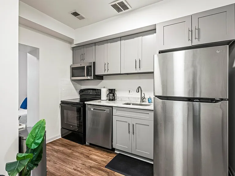 Updated kitchen with stainless steel appliances, ample shaker cabinetry, and generous counter space for meal prep.