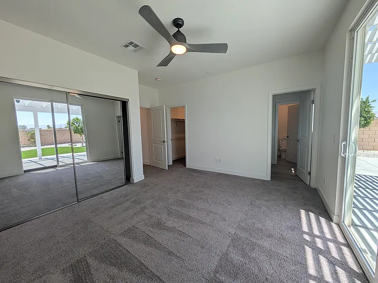 Large primary bedroom with two closet, huge bathroom and patio access