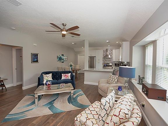 The view from the entry shows the living room, dining area and kitchen in this wonderful open concept home. Totally remodeled in 2018 with high quality materials, fixtures and finishes, the home features wood-look tile flooring throughout and an eleg