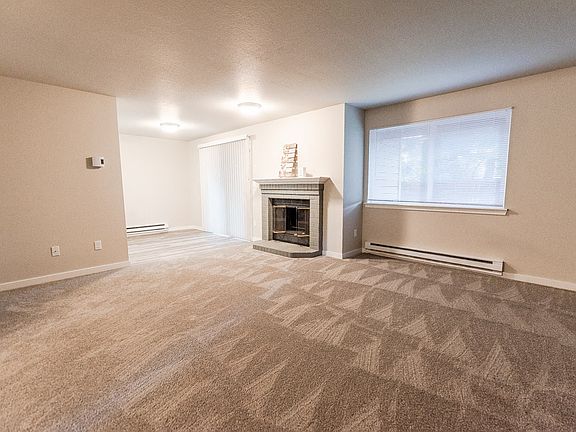 Puyallup Apartments - Cambridge on Seventh Apartments - Living Room, Fireplace, and Dining Room