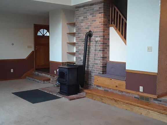 living room showing front entrance and pellet stove
