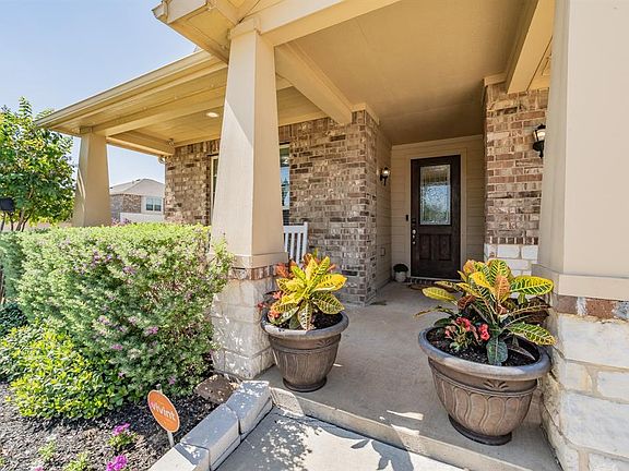 Property entrance featuring brick siding and a porch