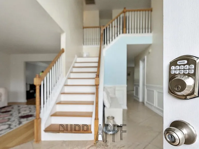 Inviting entry foyer with tiled floors, staircase to the upper level, and sightlines into adjoining living areas.
