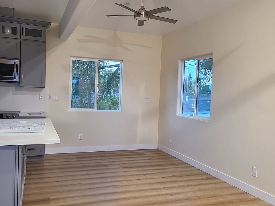 Airy & bright dining & living room with vaulted ceiling next to open kitchen