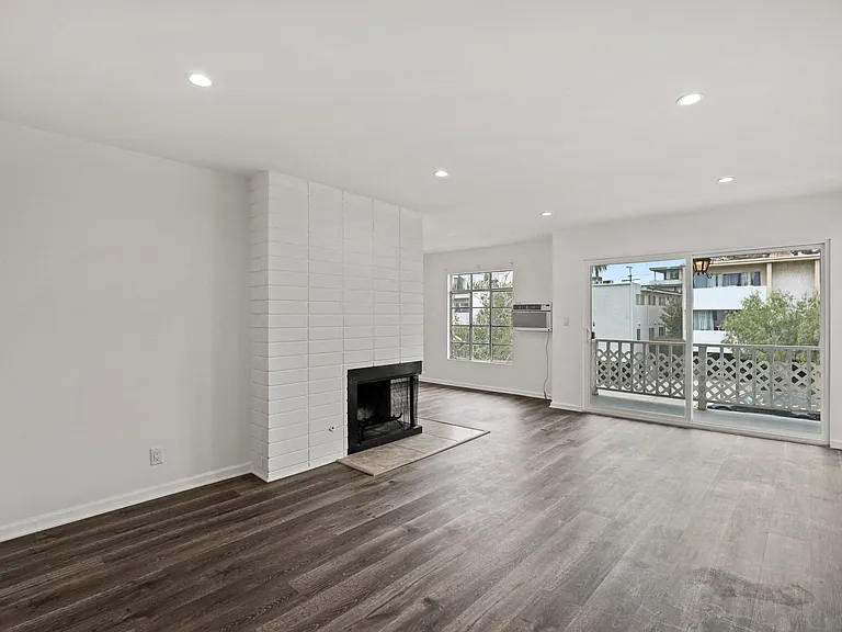 Open-Concept Living Room and Dining Room with an Electric Fireplace and Patio