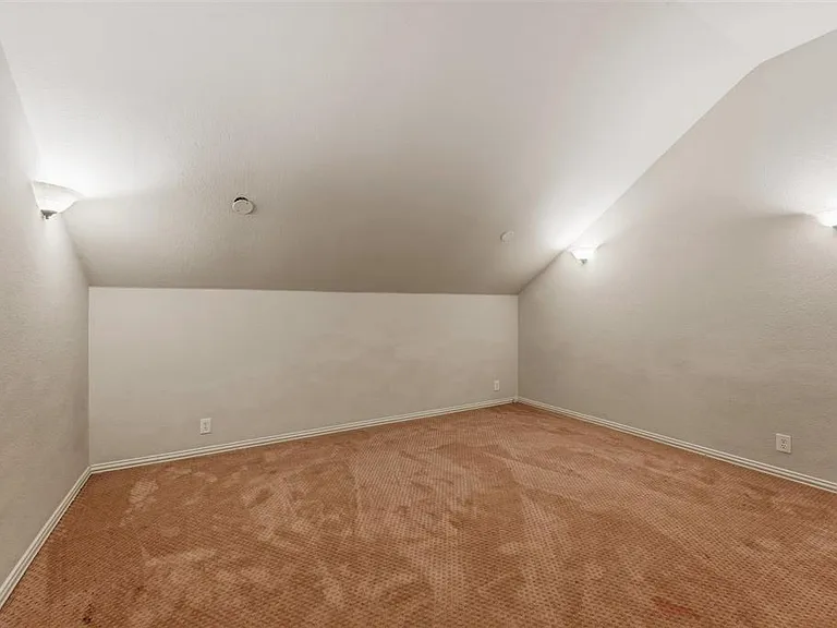 withcarpet, a ceiling fan, and wall lighting