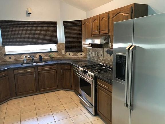 nice kitchen with high end appliances, gas range, granite countertops with matching backsplash