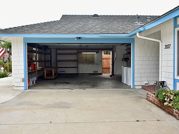 2 car garage with storage shelving, washer/dryer and irrigation timer