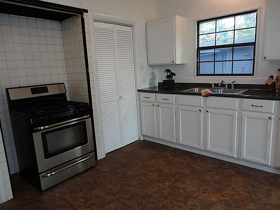  Vintage kitchen - new gas stove, new flooring -  conveniently located utility room through louvered doors.