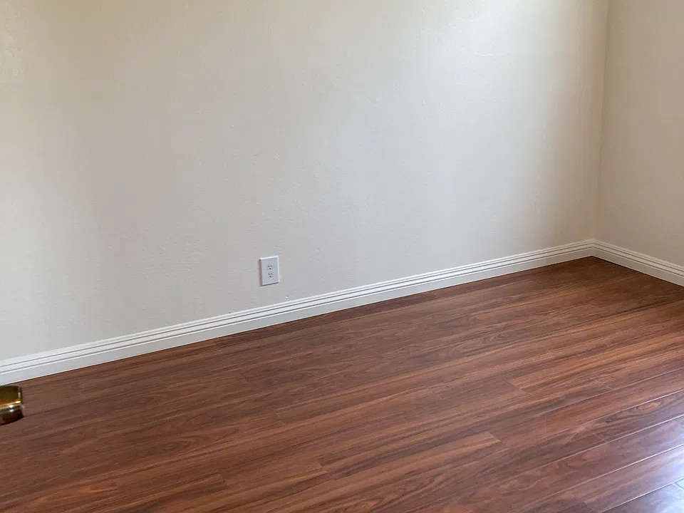 first bedroom with newly laminated flooring