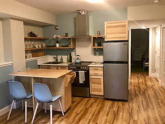 Light, bright, and modern is the theme. The vent above the stove has been finished since this picture was taken. The rolling table is optionally included and provides additional storage.
