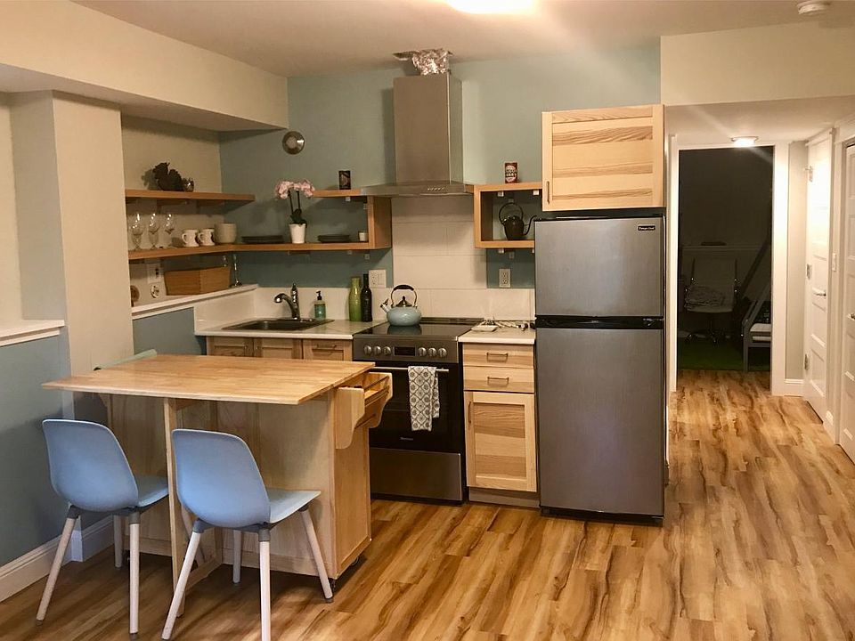 Light, bright, and modern is the theme. The vent above the stove has been finished since this picture was taken. The rolling table is optionally included and provides additional storage.