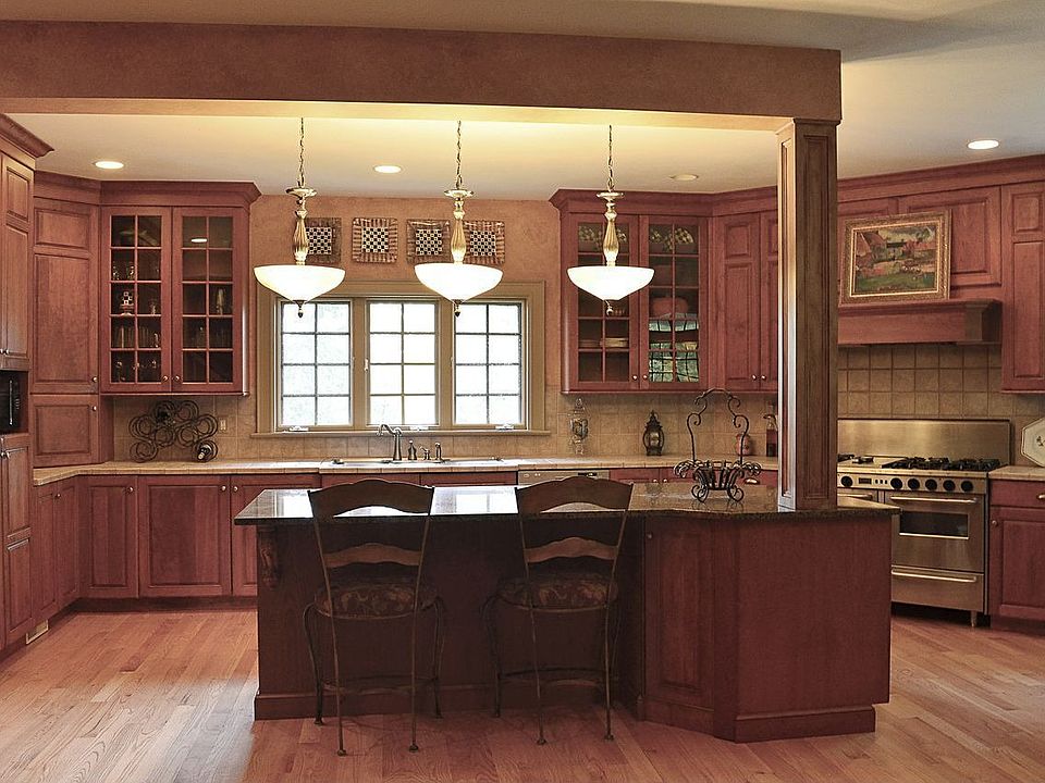 Kitchen with oversized island with granite top, cherry cabinetry, Chef's stove