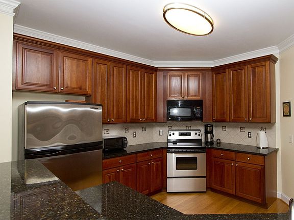 Granite counters, neutral tile backsplash and Kitchen Aid appliances enrich. 