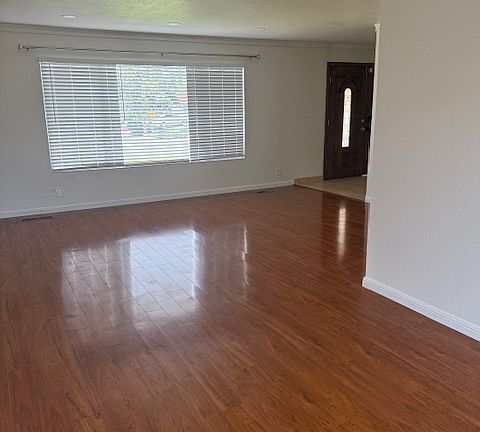 Formal living and dining area with hardwood floors, new wooden blinds