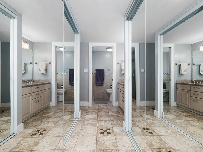 Downstairs master bedroom dual mirrored closets on both sides leading to bathroom & all glass shower.