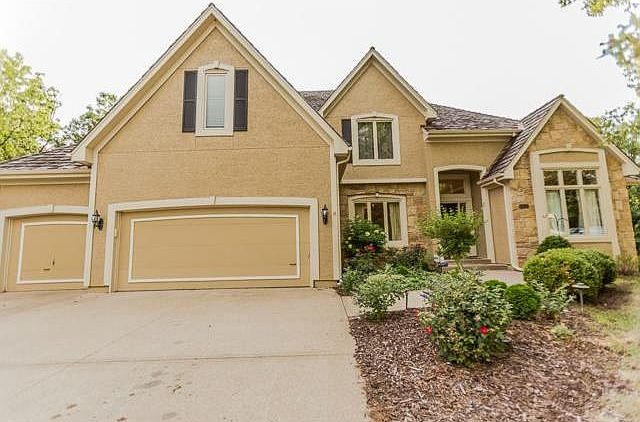 Stucco and Stone Front Elevation with a level full 3 car drivewa