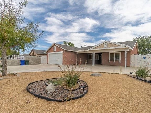 Zero to little maintenance landscaped front yard covered in concrete and pebbles. 2 extra covered car ports. 2 motor-home gate entrance on each side of the house. Decorated Wall fence and slide gate.