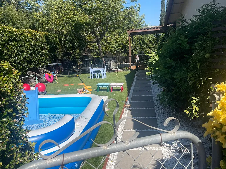 New landscaped backyard with artificial grass, stepping stones, & New Redwood Deck with Trellis