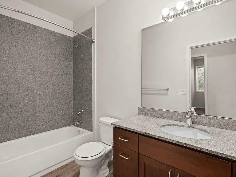 Full bathroom with granite-style vanity and tub-shower combo at Port Landing at Fife in Fife, WA. Full bathroom with granite-style vanity and tub-shower combo at Port Landing at Fife in Fife, WA.
