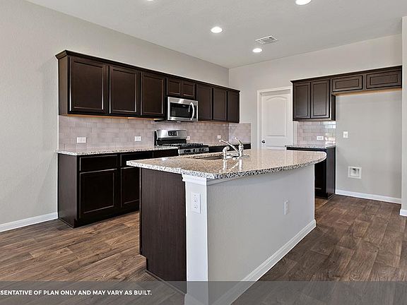 This home has quartz countertop. Refrigerator is provided. Note: This is photo of a model home with similar layout.