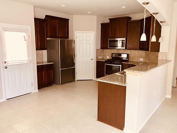 Open Kitchen layout with stainless steel appliances, beautiful maple cabintes and granite countertops, including a raised breakfast bar.