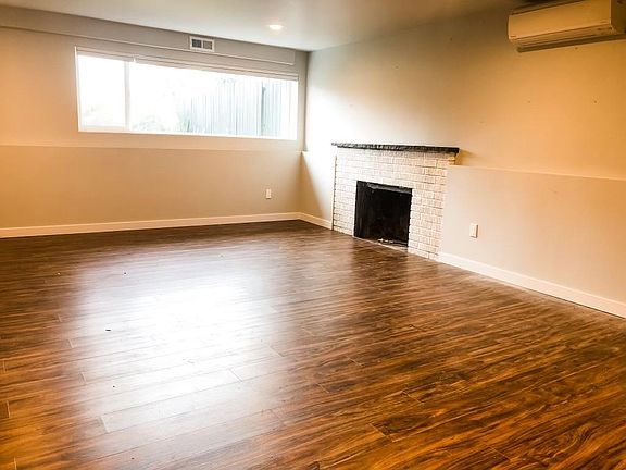 Kitchen is open to well-lit living room with in-room ductless hvac to augment central gas heating