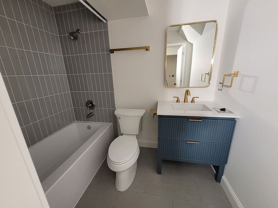 Tile bathroom, back-lit mirror, gold finishes