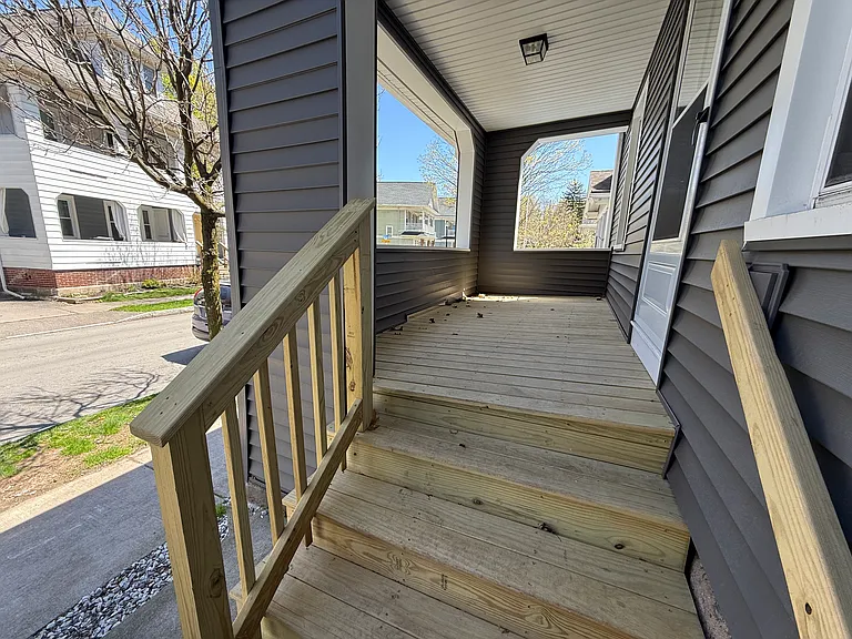 New porch and steps, installed in early 2025. Porch and steps will be stained with a darker finish in the near future. Unit has new front door and screen door.