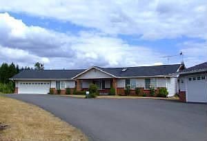 Front of home with 2 car attached garage and 4 car detached garage